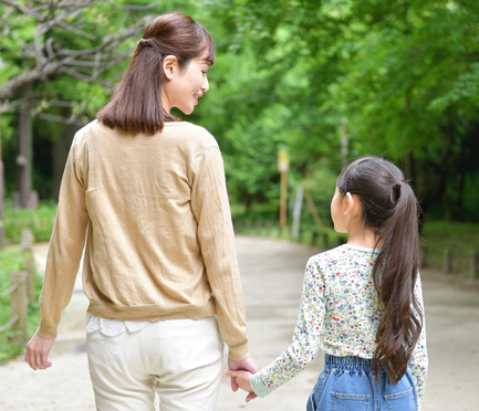親子が公園で手をつなぐイメージ写真