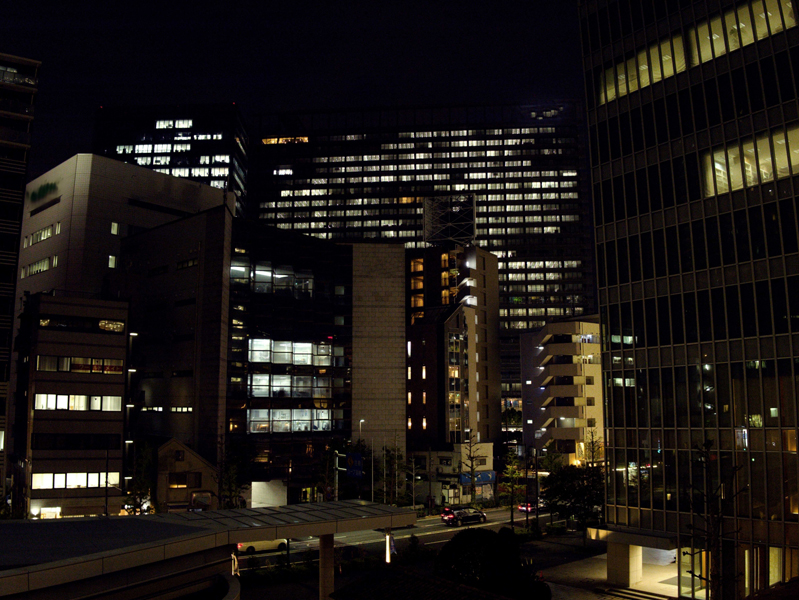 残業する夜の街の夜景とオフィスビル